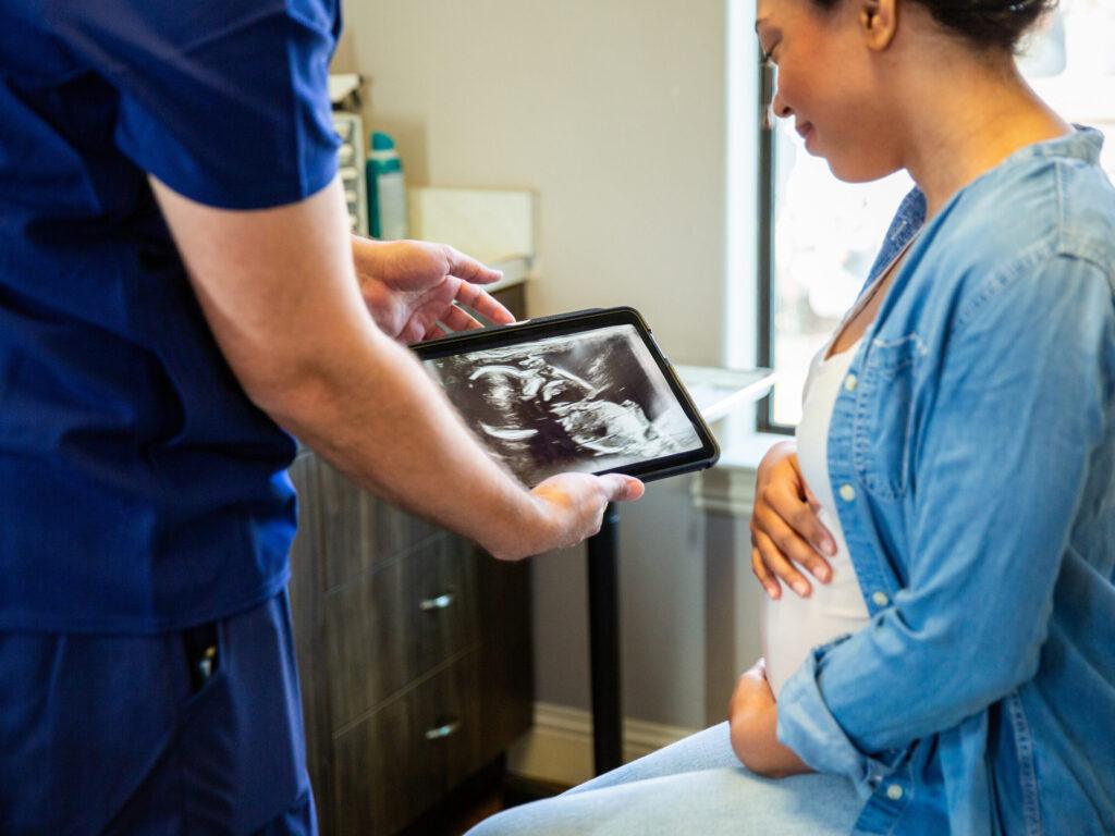 Patient receiving prenatal care during an exam, highlighting fertility and family-building benefits in employer health plans.