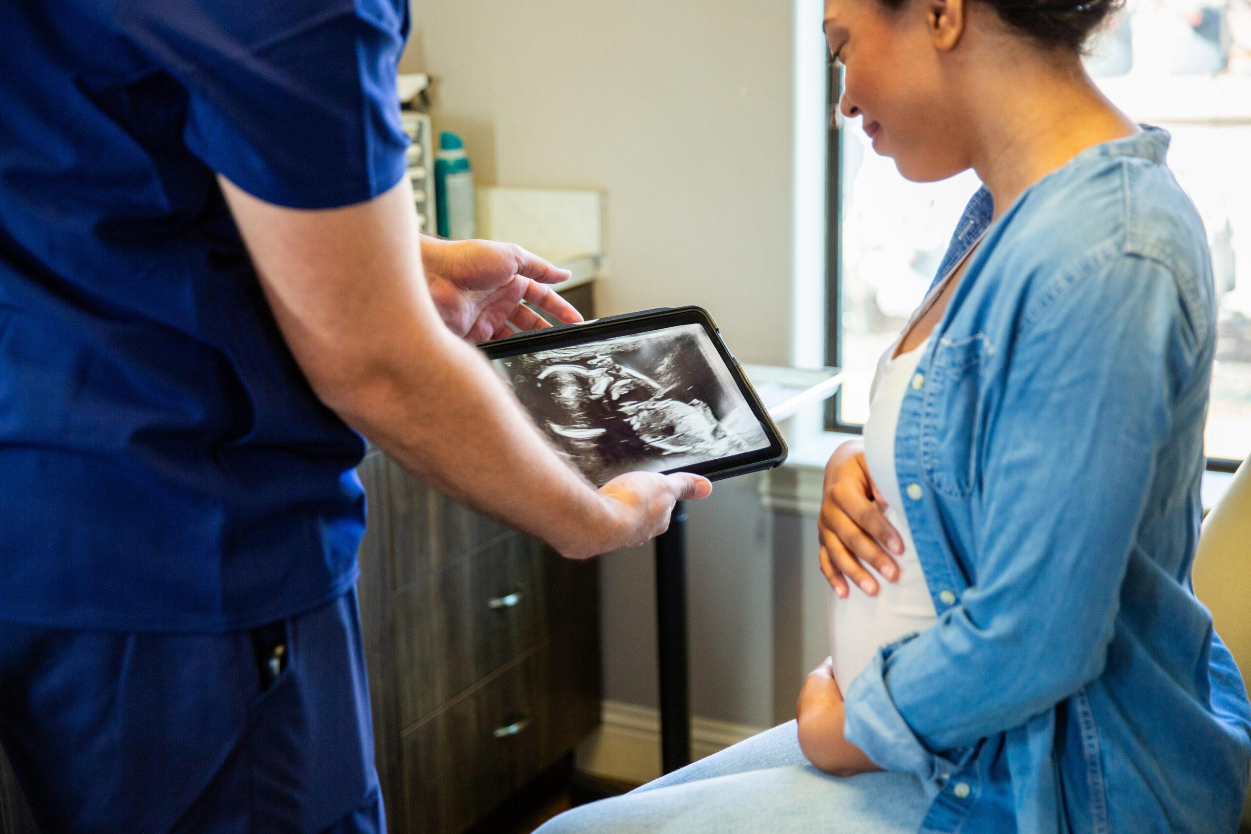 Patient receiving prenatal care during an exam, highlighting fertility and family-building benefits in employer health plans.